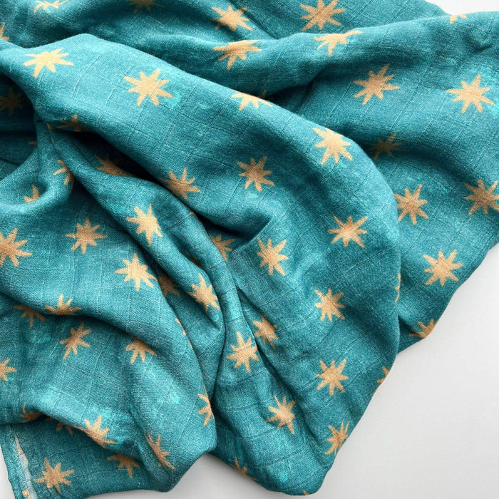 Teal fabric with gold star patterns on a white background