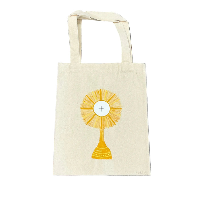 Small white bag with a monstrance design on a floral patterned fabric background