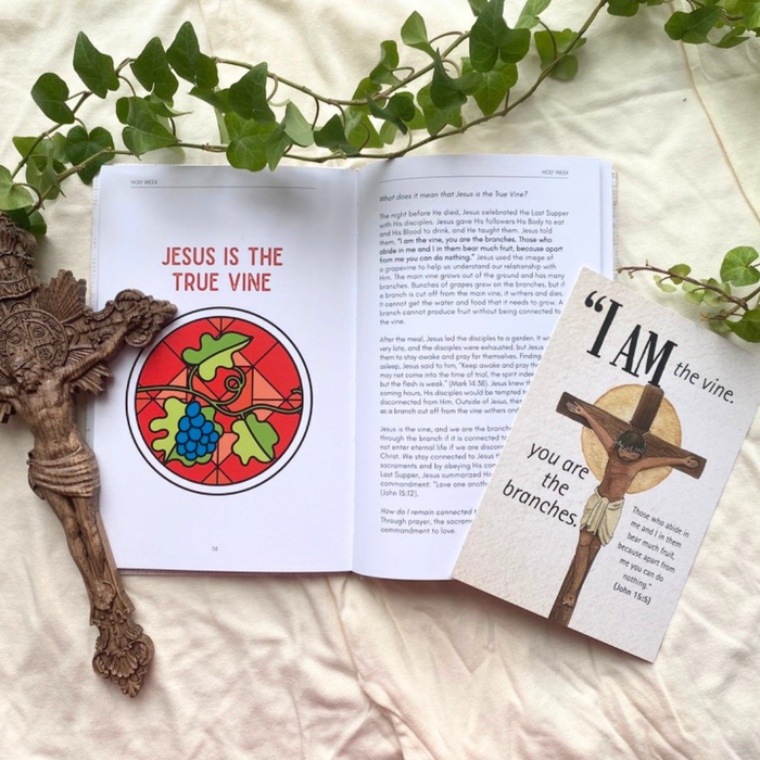 Open book with religious illustrations and text, including a crucifix and greenery.