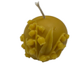 Yellow beeswax candle with floral design on a white background