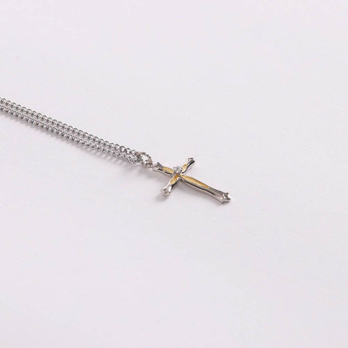 Silver chain necklace with a cross pendant on a white background