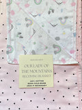 Baby receiving blanket with rainbow and nature pattern on a polka dot background