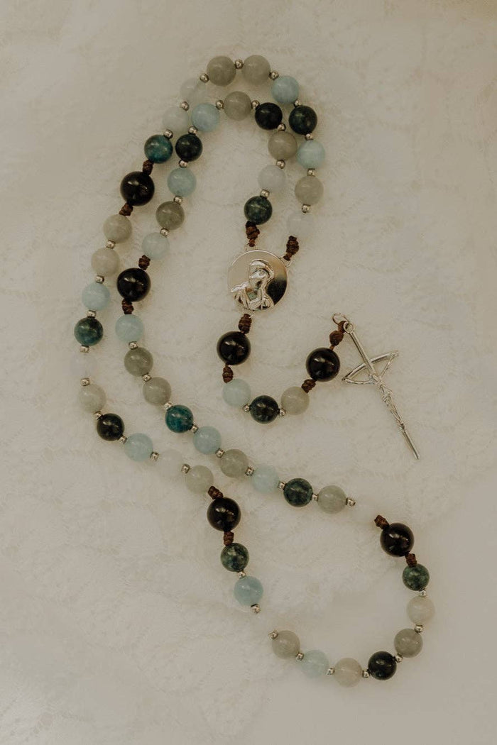 Beaded rosary with a cross pendant on a light background