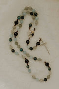 Beaded rosary with a cross pendant on a light background