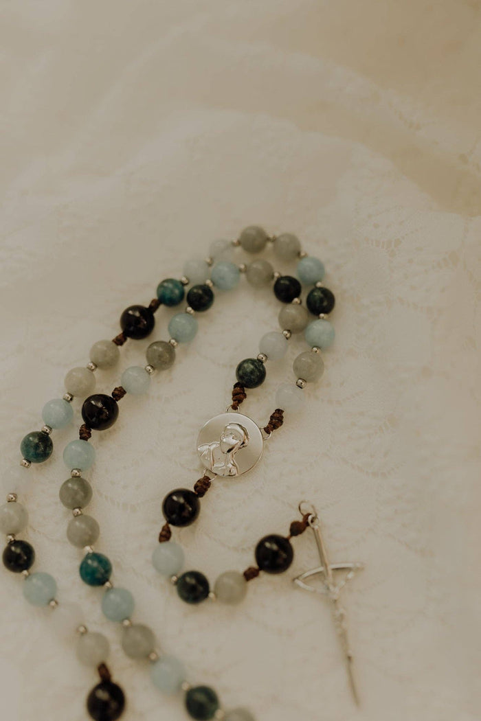 Beaded rosary with a cross pendant on a light background