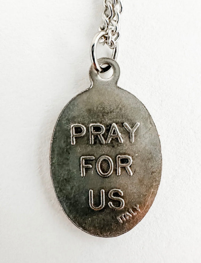 Silver pendant with 'PRAY FOR US' text on a white background