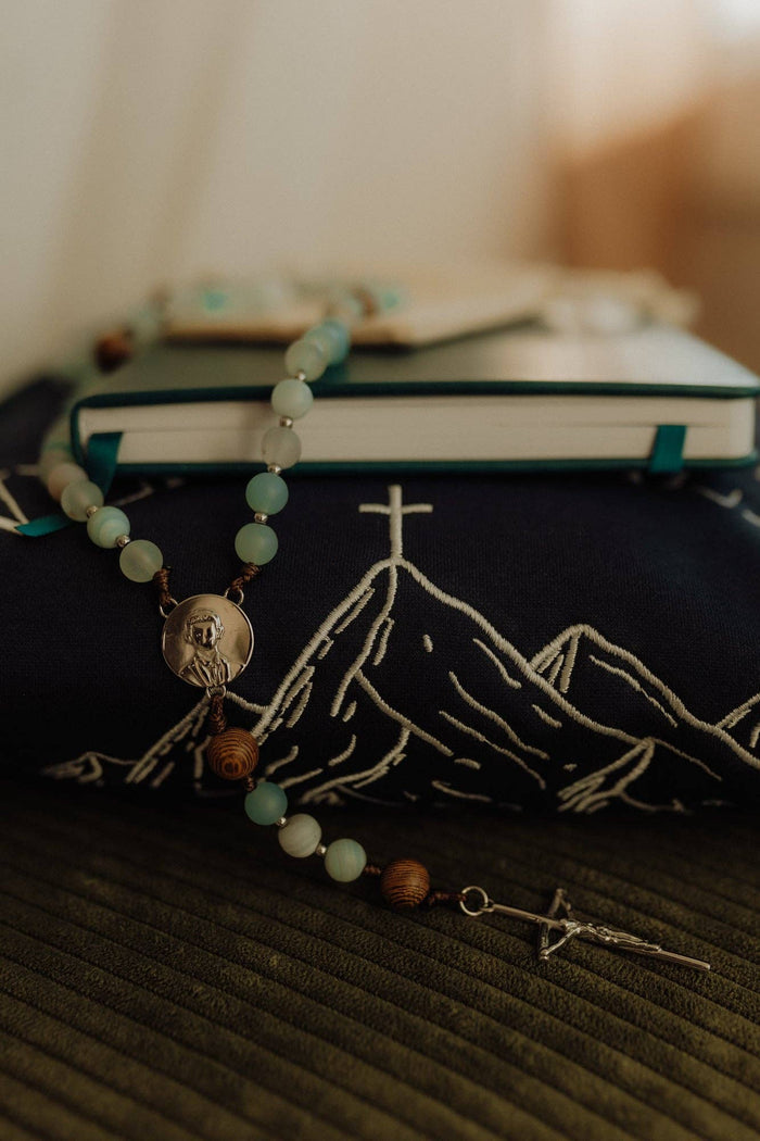 Rosary with mountain design on a book