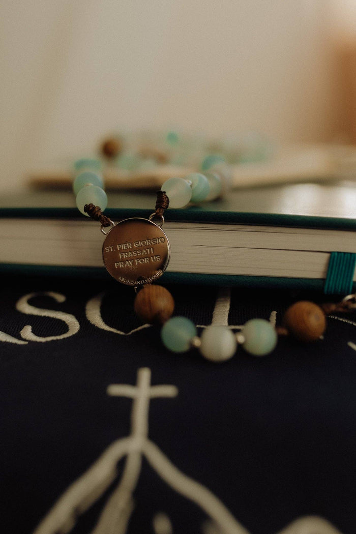 Rosary with a pendant on a book with a blurred background