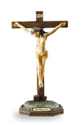 Statue of a figure on a cross with gold and brown colors on a white background