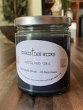 Jar of Christian Wicks Woodland Spice candle on a wooden surface
